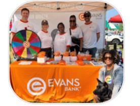 A group of people standing in front of a table

Description automatically generated