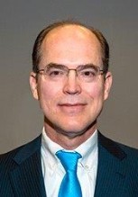 A person wearing glasses and a suit

Description automatically generated with medium confidence