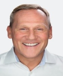 A person smiling at the camera

Description automatically generated