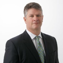 A person in a suit and tie  Description automatically generated with medium confidence